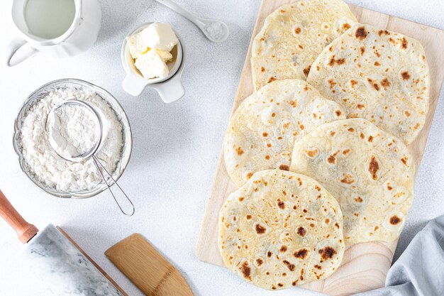 Tortillas de blé faites maison pita pain tortilla pita avec des ingrédients pour cuisiner sur une table blanche Vue supérieure