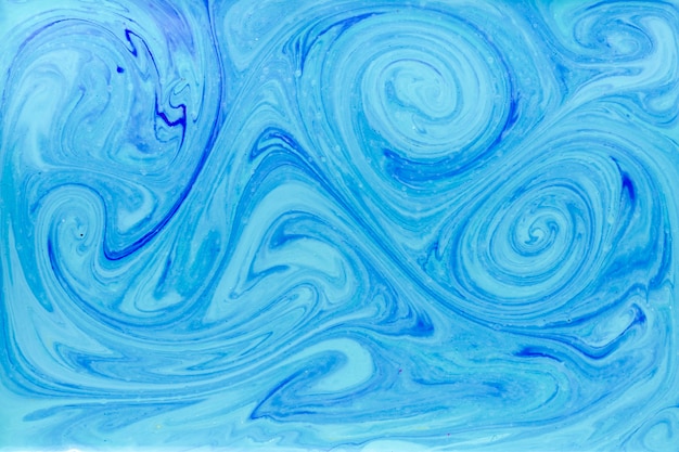 Tourbillonne dans le liquide avec de la peinture bleue