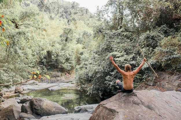 touriste est assis sur une pierre dans la forêt. Sumbawa