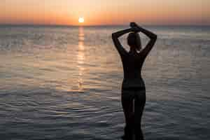 Photo gratuite touriste en maillot de bain en regardant le lever du soleil