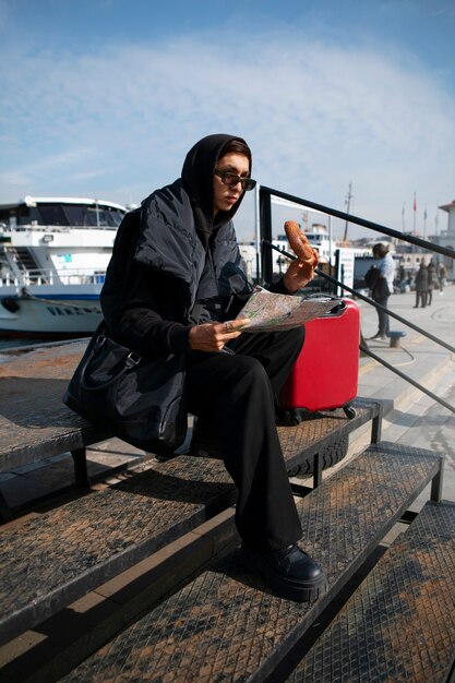 Touriste masculin vérifiant la carte à côté de la valise