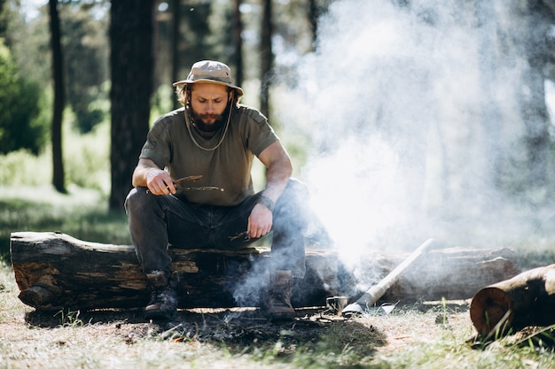 Touriste par feu de joie en forêt