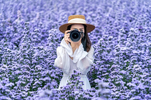 Touriste prendre une photo avec un appareil photo numérique dans les champs de fleurs de margaret