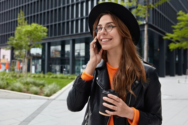 Une touriste souriante partage ses impressions sur les vacances avec un ami