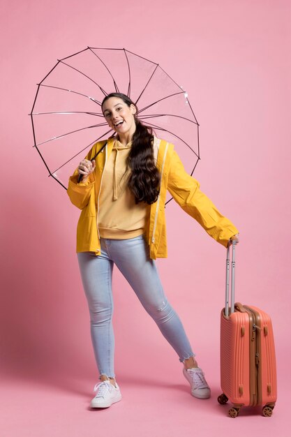 Touriste tenant ses bagages et son parapluie