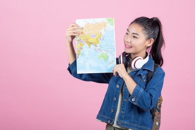 Touristes femmes en studio sur fond rose.