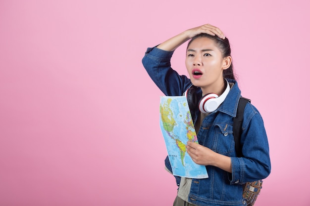 Touristes femmes en studio sur fond rose.