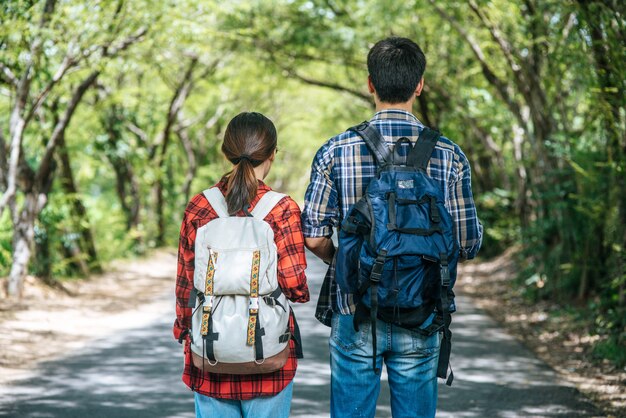 Les touristes masculins et féminins se tiennent pour voir la carte sur la route.