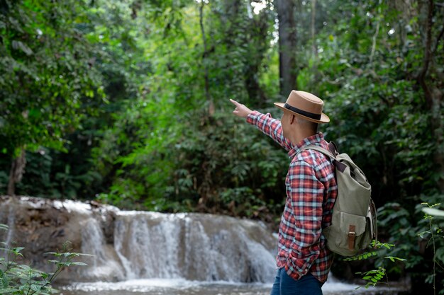 Les touristes masculins sont heureux et reposés à la cascade.