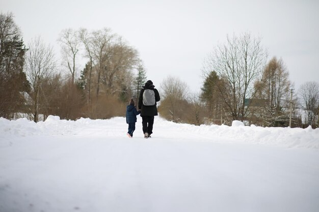 Les touristes voyagent à travers le pays enneigé. sur le chemin, marchez et faites de l'auto-stop.