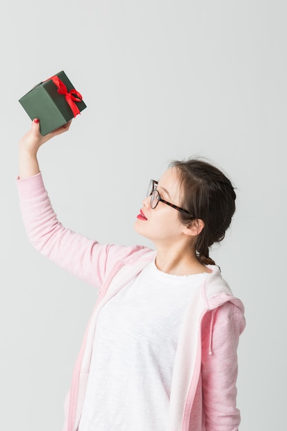 Tourné dans le studio de la jeune femme asiatique avec un cadeau de Noël