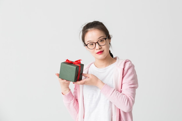 Tourné dans le studio de la jeune femme asiatique avec un cadeau de Noël