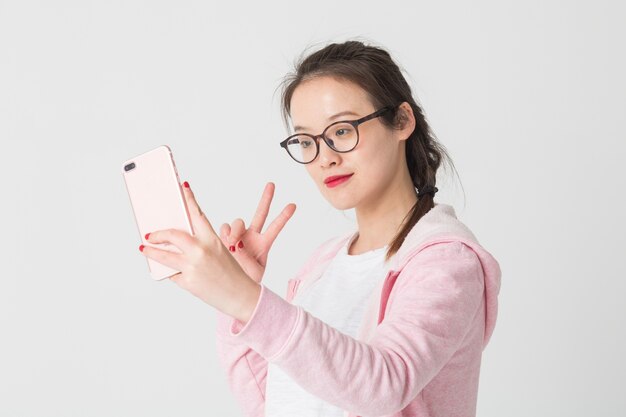 Tourné dans le studio de jeunes femmes asiatiques dans l&#39;utilisation de l&#39;entreprise de téléphonie mobile