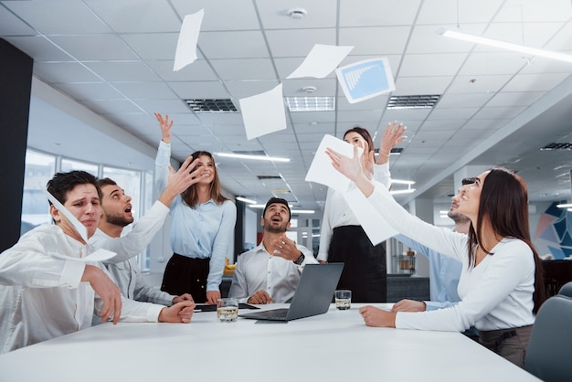 Tous les papiers en l'air. La tâche est finie. Un groupe d'employés de bureau heureux de battre leurs propres records et de réussir