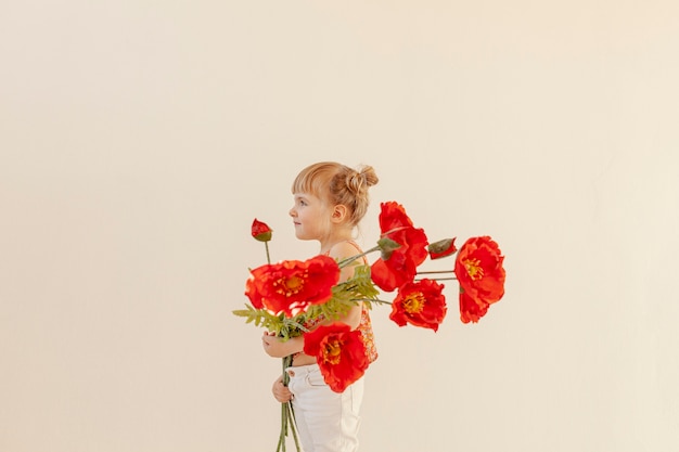 Tout-petit mignon tenant de grandes fleurs