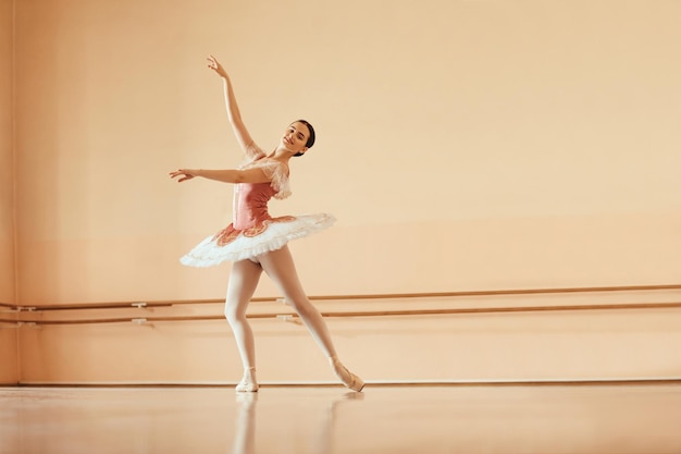 Toute la longueur des danses de ballet souriantes répétant au studio de danse Espace de copie