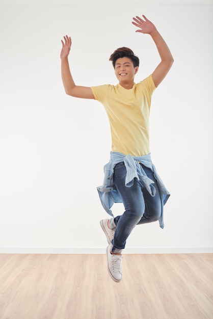 Toute la longueur d'un joyeux mec asiatique qui danse