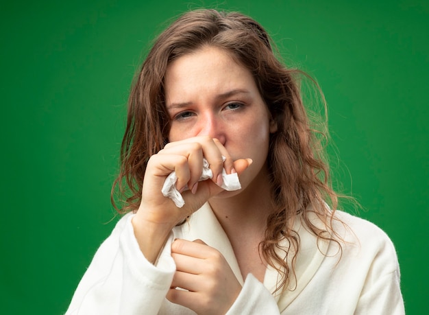 Toux jeune fille malade regardant droit devant portant une robe blanche tenant la main sur la bouche isolé sur vert