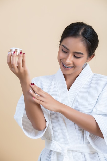 Un traitement de beauté avec une femme tient un hydratant à la main