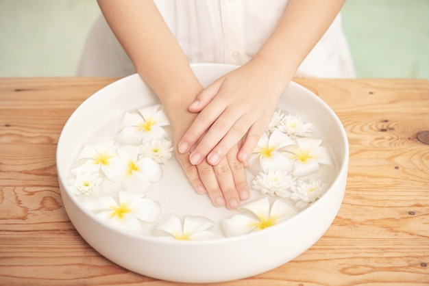 Traitement et produit de spa. fleurs blanches dans un bol en céramique avec de l'eau pour l'aromathérapie au spa.