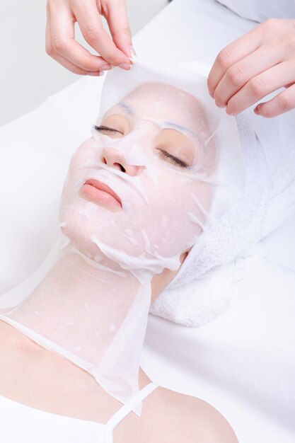 Traitement spa pour le visage de la jeune femme dans le salon de beauté