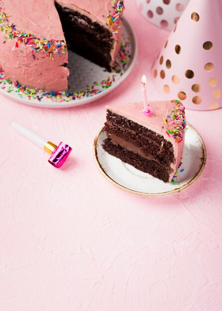 Tranche d'angle élevé de gâteau rose avec bougie