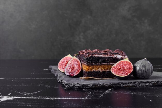 Une tranche carrée de gâteau au fromage au chocolat avec des figues.