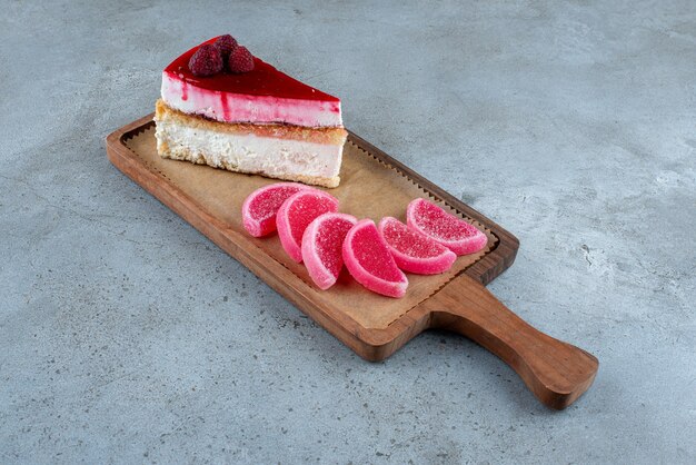 Tranche de cheesecake avec marmelades sur planche de bois. photo de haute qualité