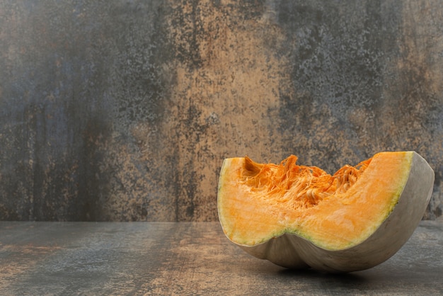 Une tranche de citrouille jaune fraîche sur une surface en marbre