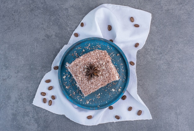 Tranche de gâteau au cacao sur plaque bleue.