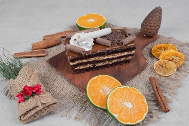 Tranche de gâteau au chocolat, cannelle et tranches de mandarine sur toile de jute.