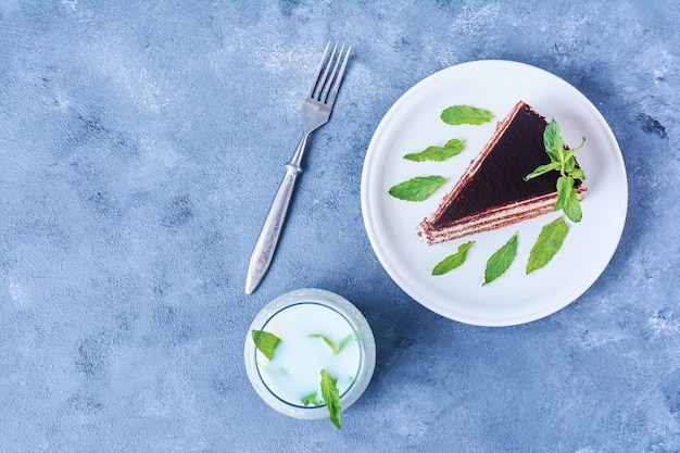 Une tranche de gâteau au chocolat dans une assiette blanche avec du lait.