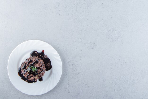 Tranche de gâteau au chocolat décorée de sirop sur plaque blanche. photo de haute qualité