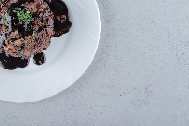 Tranche de gâteau au chocolat décorée de sirop sur plaque blanche. photo de haute qualité