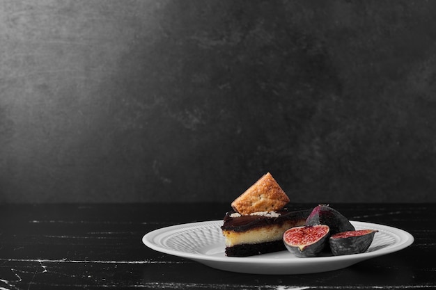 Une tranche de gâteau au chocolat avec des fruits de côté.