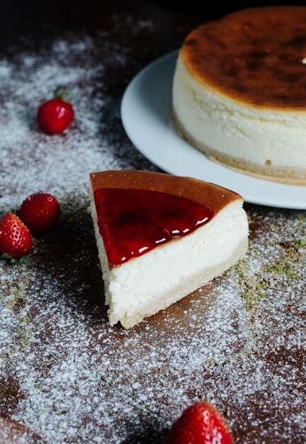 Photo gratuite une tranche de gâteau au fromage avec du sirop de caramel à la fraise sur le dessus.