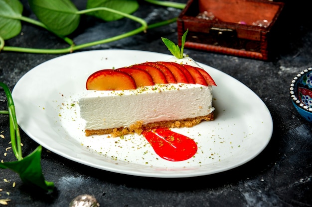 Photo gratuite tranche de gâteau au fromage garnie de tranches de prune et de sirop