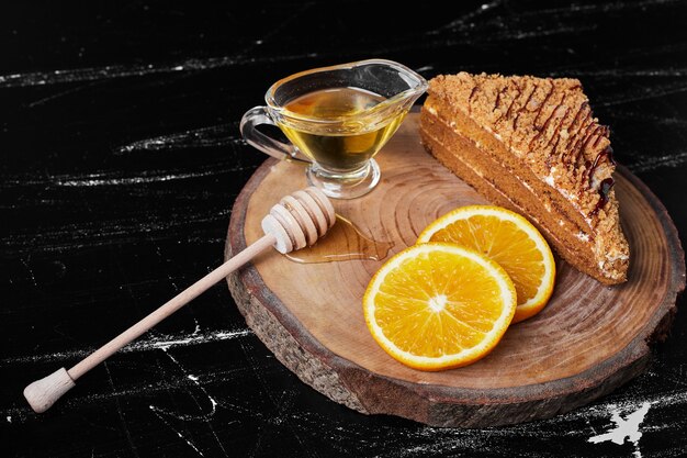 Une tranche de gâteau au miel avec des tranches d'orange et du sirop