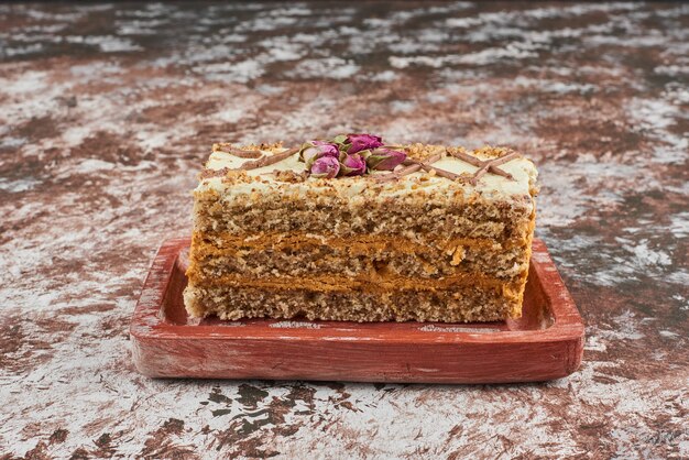 Une tranche de gâteau aux carottes sur une planche de bois.