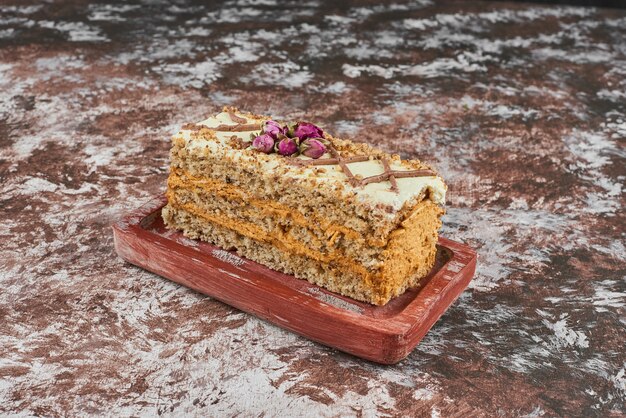 Une tranche de gâteau aux noix sur une planche de bois.