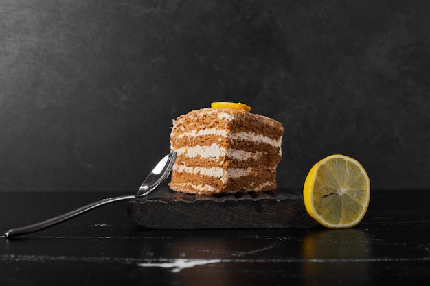Une tranche de gâteau medovic servie avec du citron.