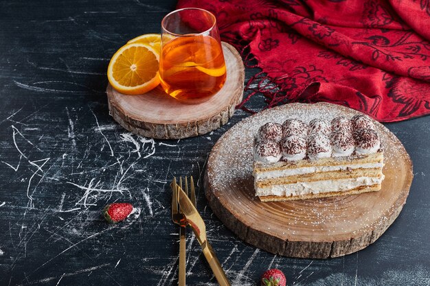 Une tranche de gâteau sur une planche de bois, vue du dessus.