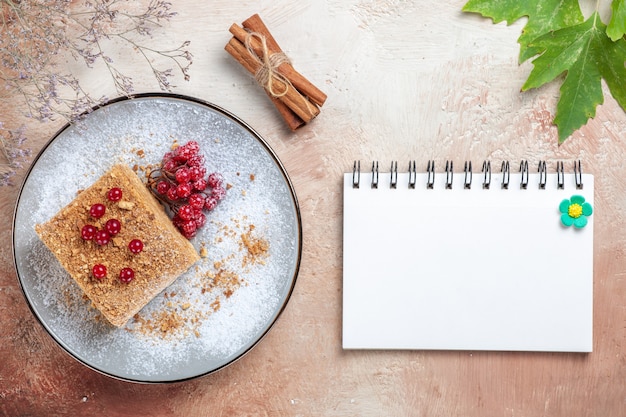 Tranche de gâteau vue de dessus avec des baies rouges à la lumière