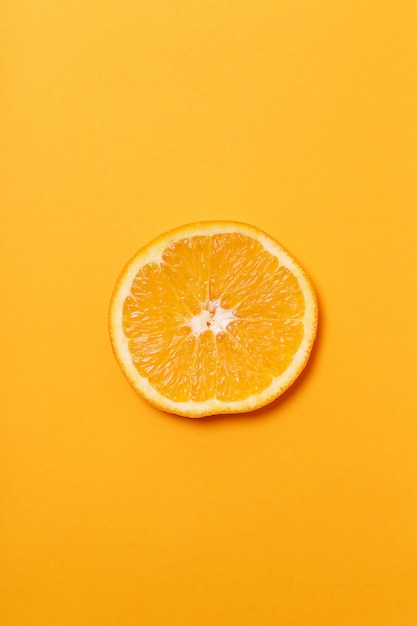 Tranche d'orange isolée sur une surface orange