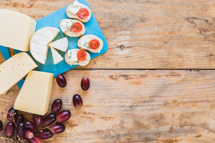 Photo gratuit tranche de pain aux tomates et au fromage avec des raisins sur la table