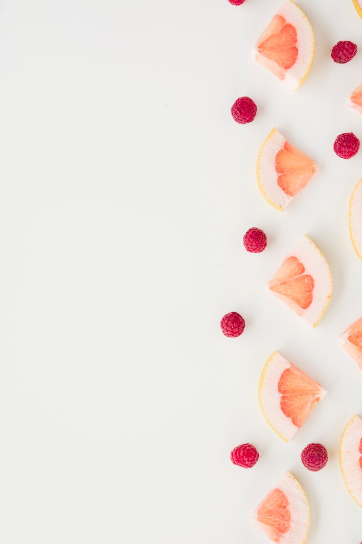 Photo gratuit tranche de pamplemousse et framboises isolés sur fond blanc
