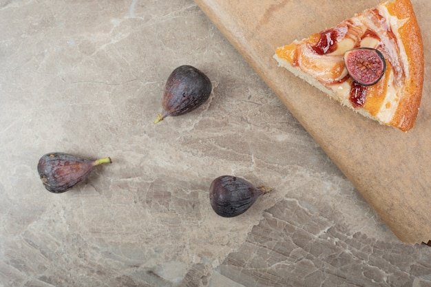 Tranche de tarte et figues fraîches sur planche de bois. Photo de haute qualité