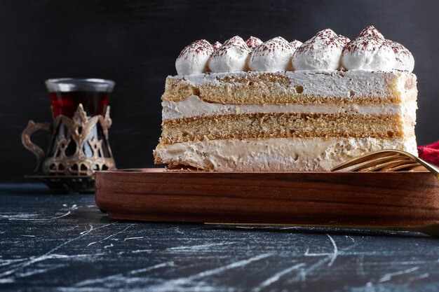 Une tranche de tiramisu avec un verre de thé.