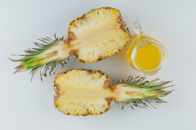 Tranches d'ananas avec du jus sur une surface blanche