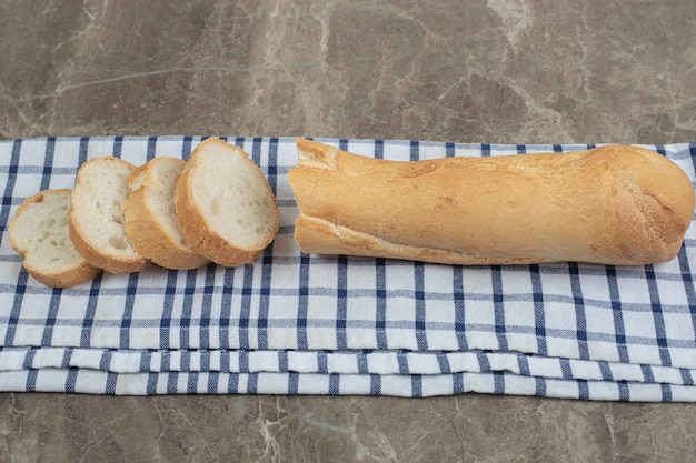 Tranches de baguette fraîche sur nappe bleue. Photo de haute qualité